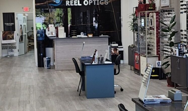 Reception desk and showroom under the illuminated Reel Optics sign