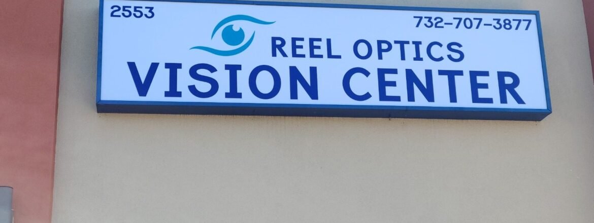 Reel Optics Vision Center sign showing street number 2553 and phone number