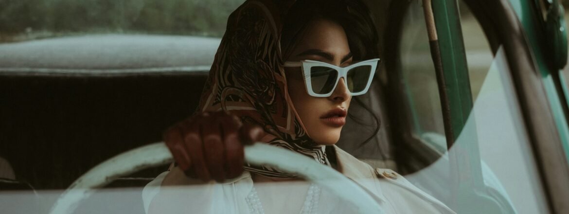 Woman wearing sunglasses while driving in bright daylight